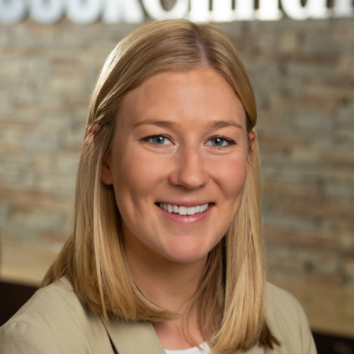 Smiling blonde woman in tan blazer