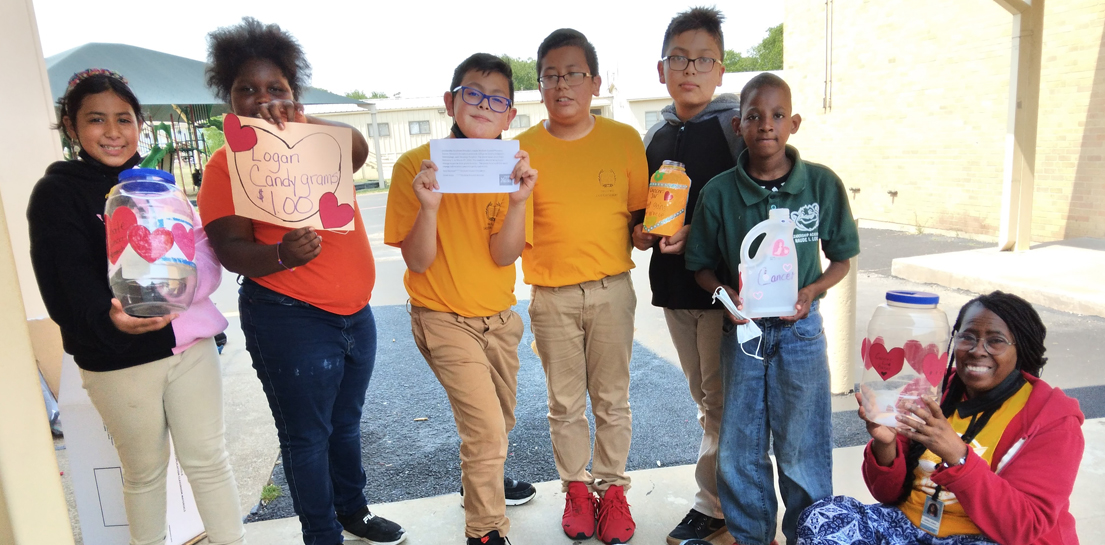 Children and teacher from the Leadership Academy with their donation jars