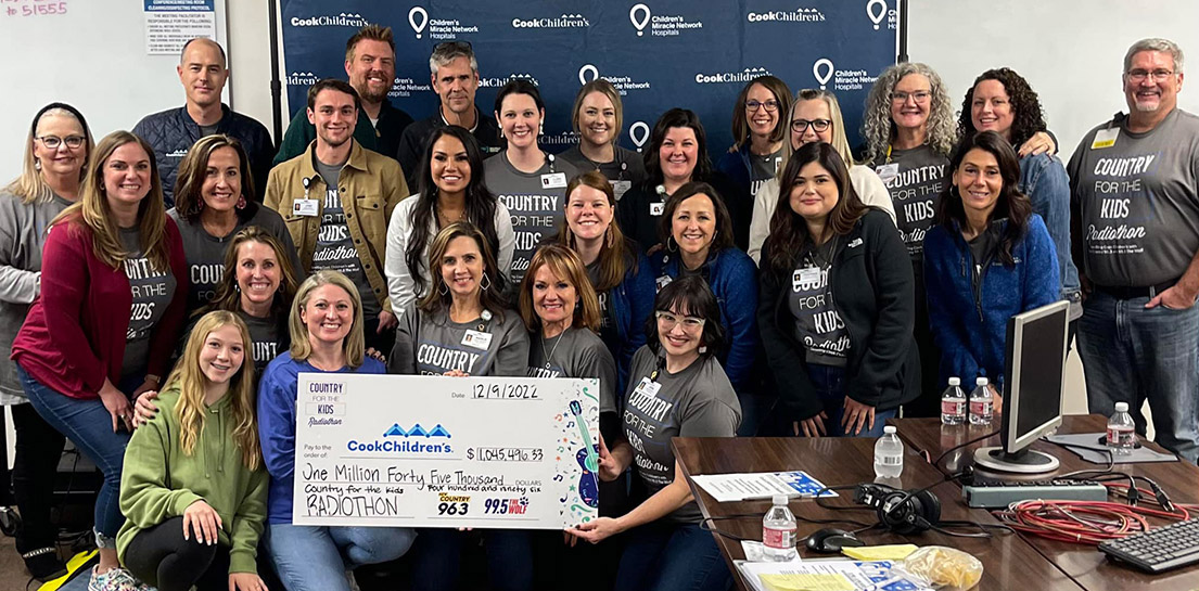 Volunteers, Cook Children's employees and radiothon members with giant check