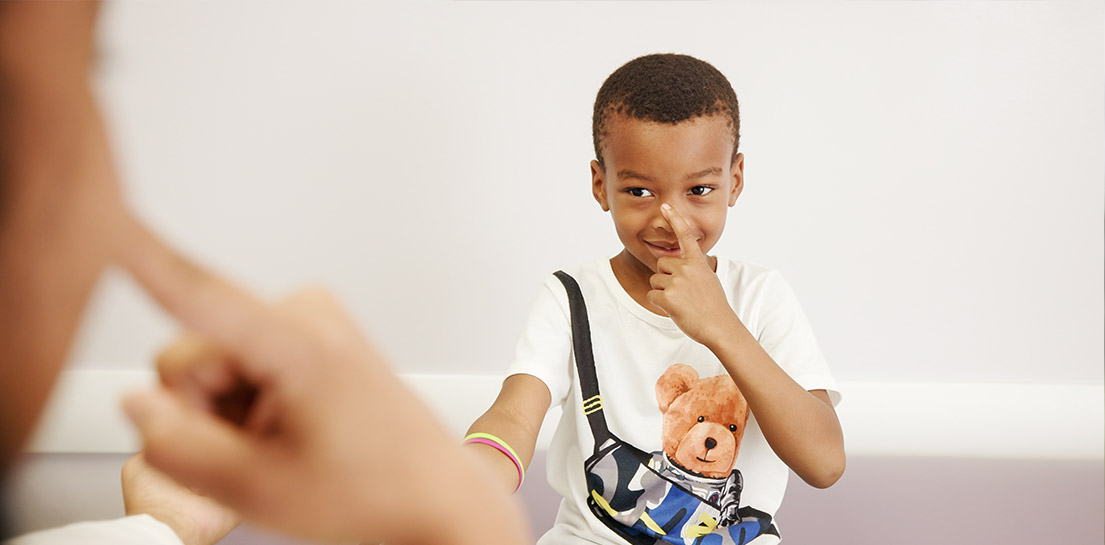 African American boy touching nose and smiling