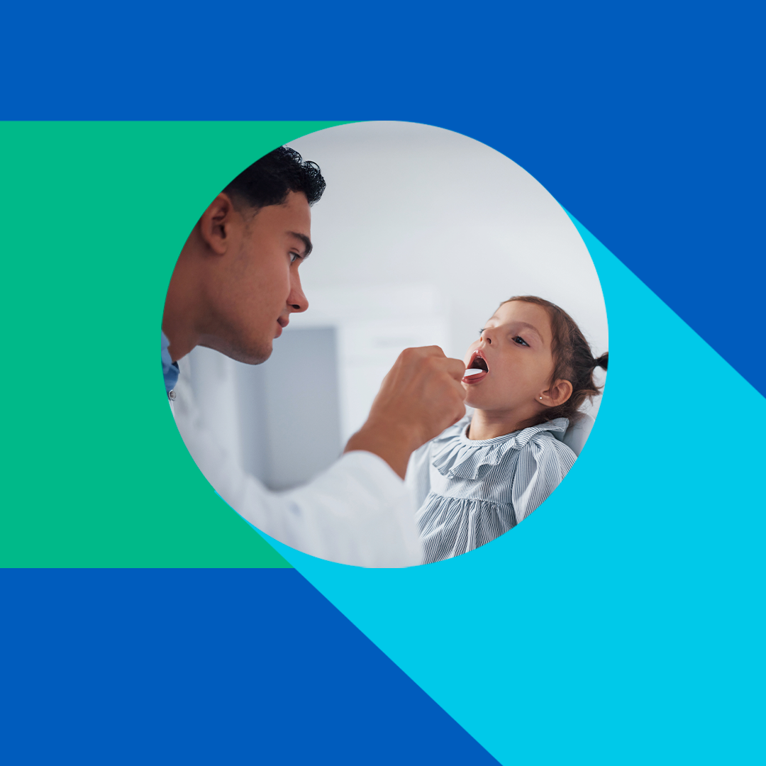 Pediatrician examines a young girl's throat with a tongue depressor
