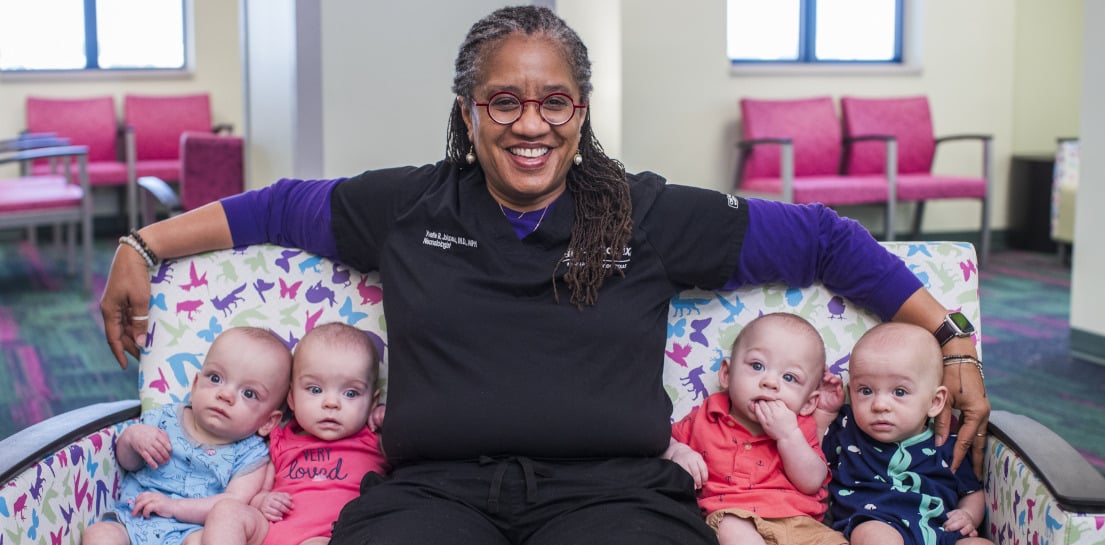 Endowed Chair and neonatologist Yvette Johnson, M.D., MPH, holds quadruplet babies at Cook Children’s NEST Developmental Follow-up Center.