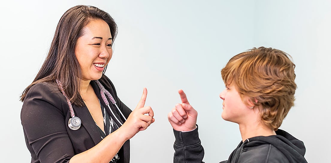 Neuro-oncologist and Endowed Chair Sibo Zhao, M.D., interacts with patient in clinic