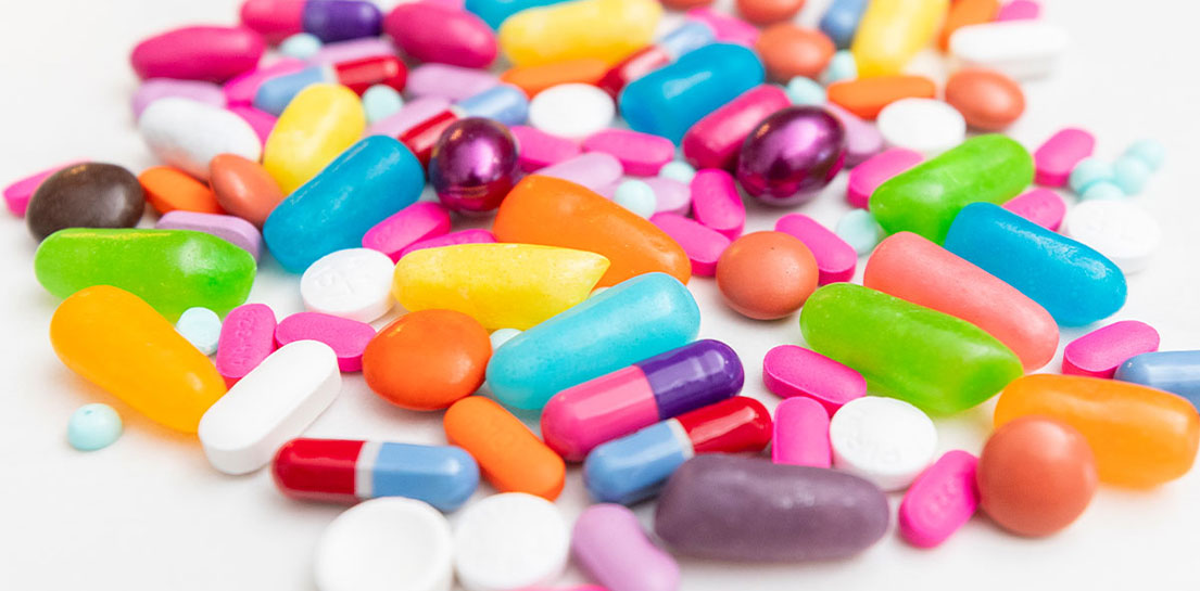 Pile of colorful candies and pills mixed together showing that it&rsquo;s hard to tell them apart